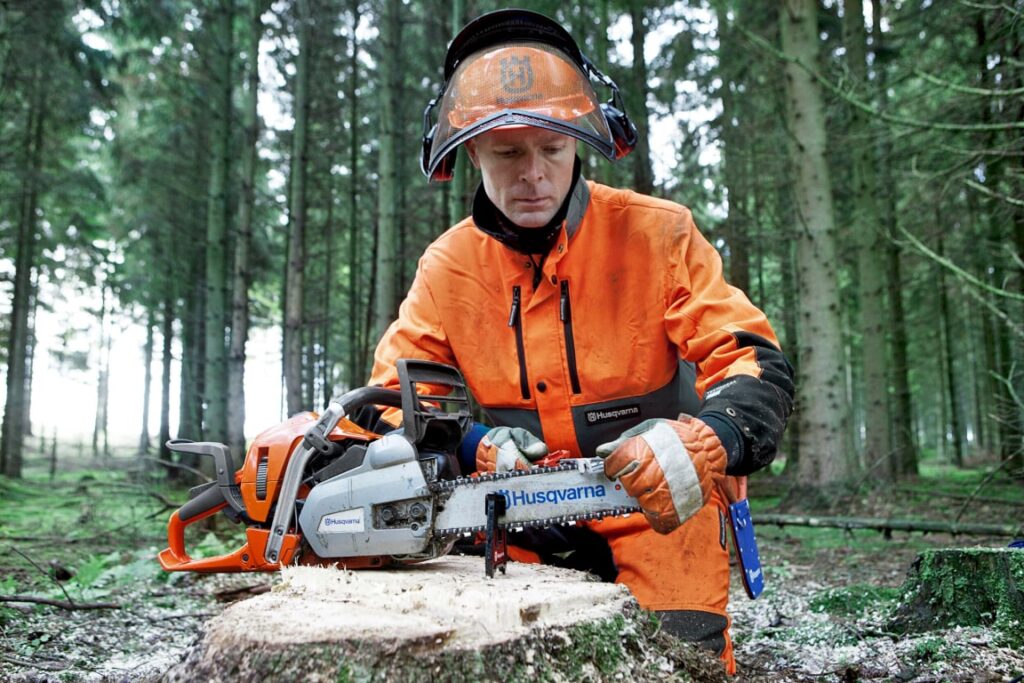 trabajador forestal preparando cadena de motosierra