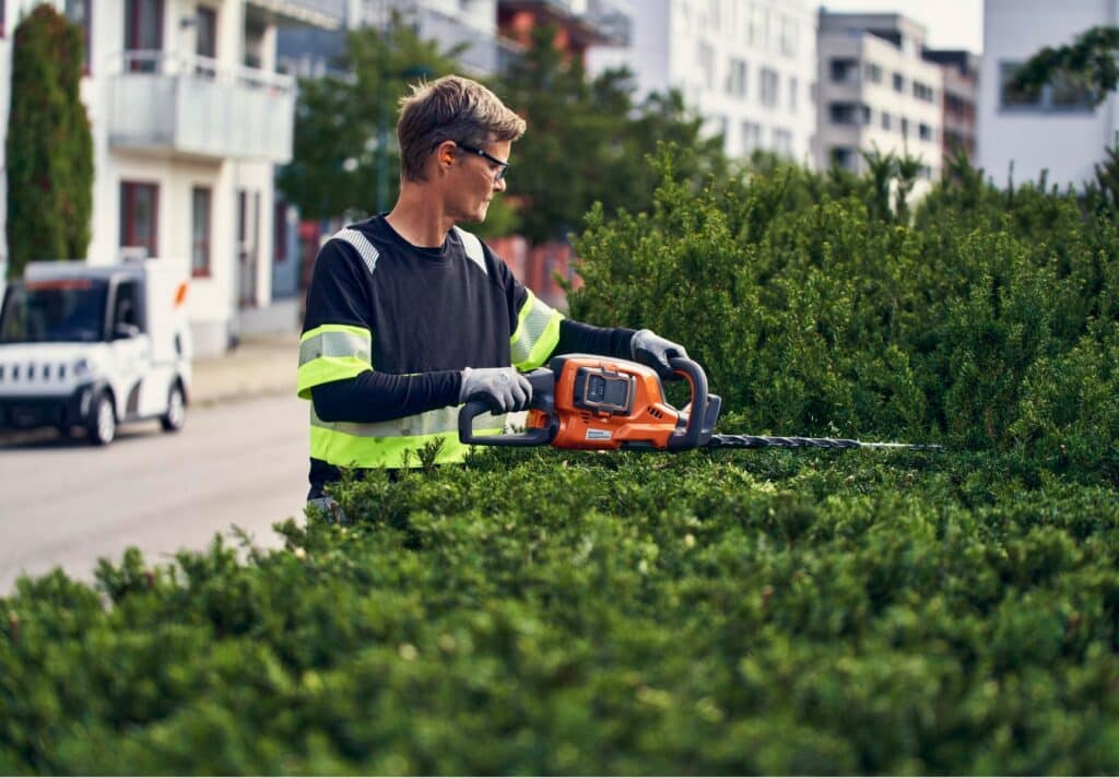 trabajo de jardinería con cortasetos a batería Husqvarna